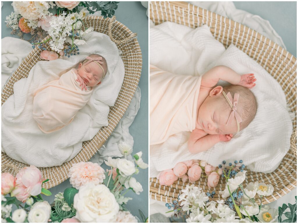 A newborn baby girl wrapped in a pink swaddle in a basket surrounded by flowers